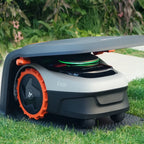 Robotic lawn mower on a grassy area with a garden background